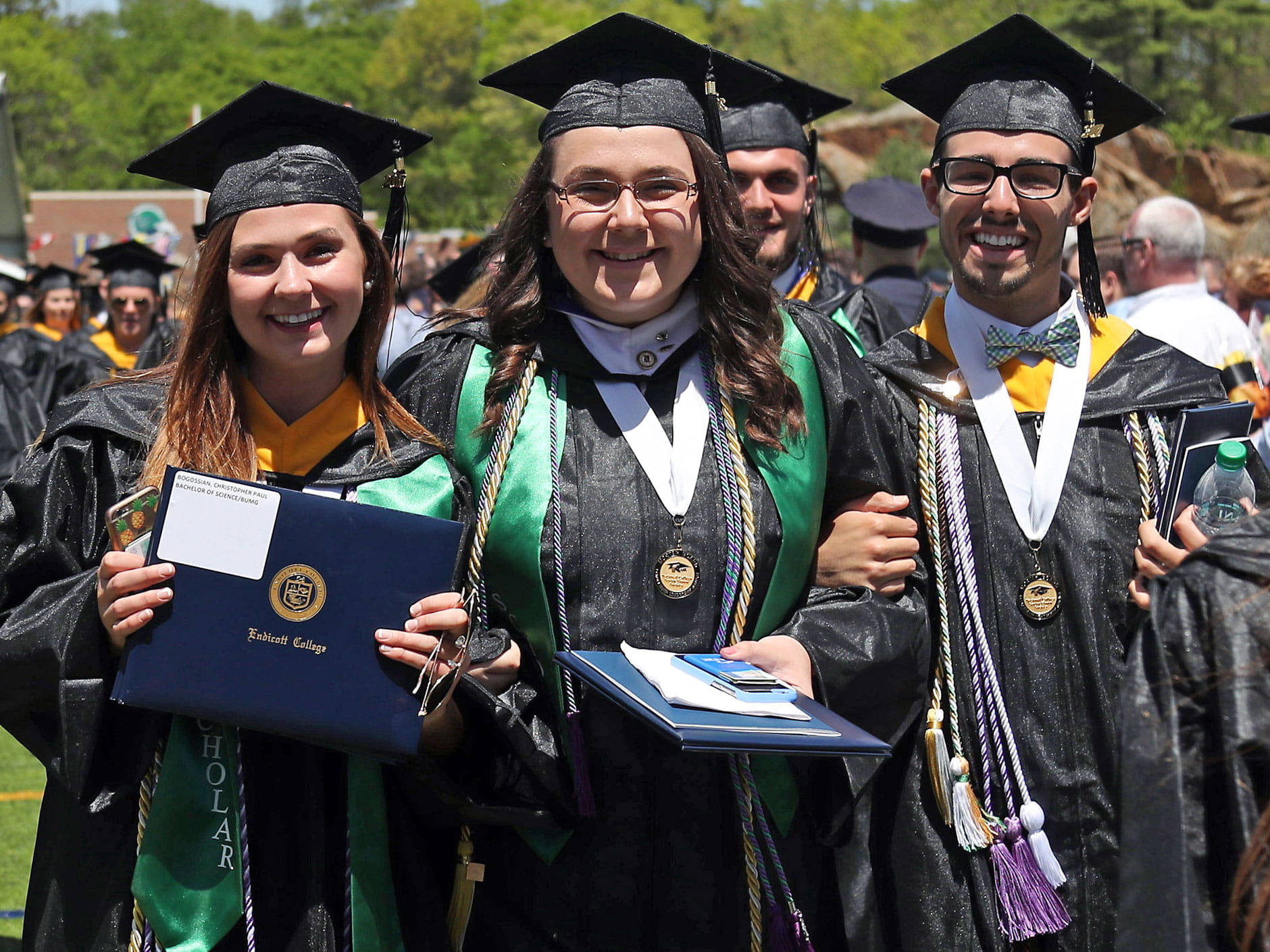 Students with diplomas following graduation ceremony