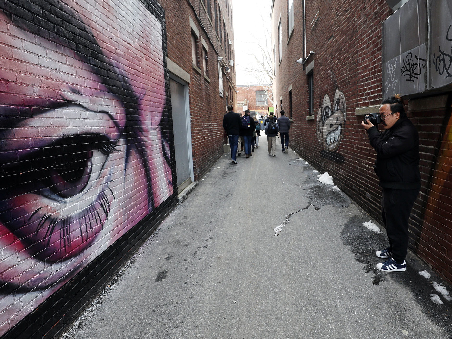 Students in The Point in Salem walking through an alley with murals. 