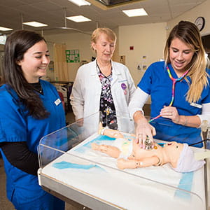 Nursing students work on simulator subjects in the lab