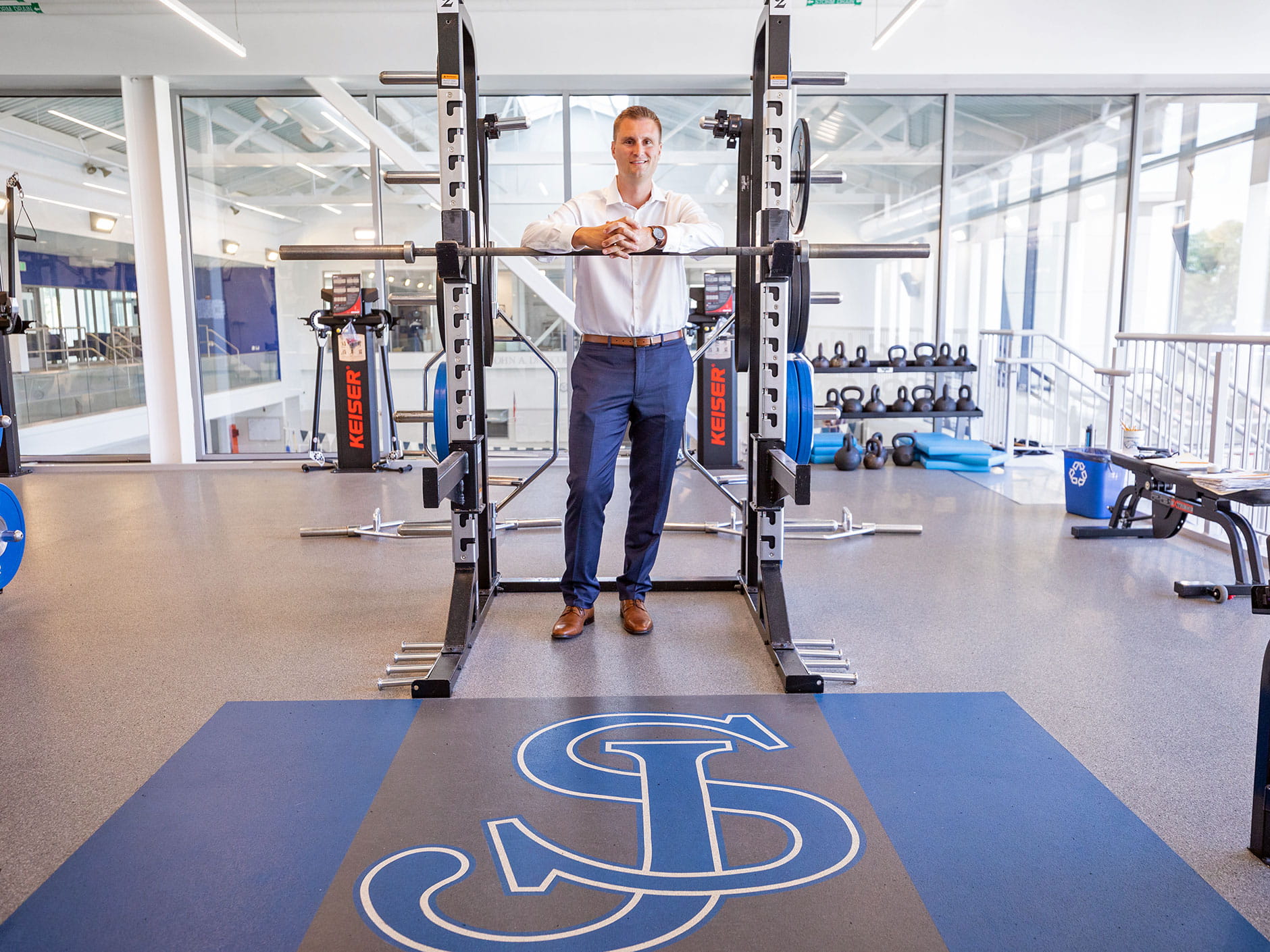 Jameson Pelkey leaning over a squat rack inside the St. John's Prep Wellness Center