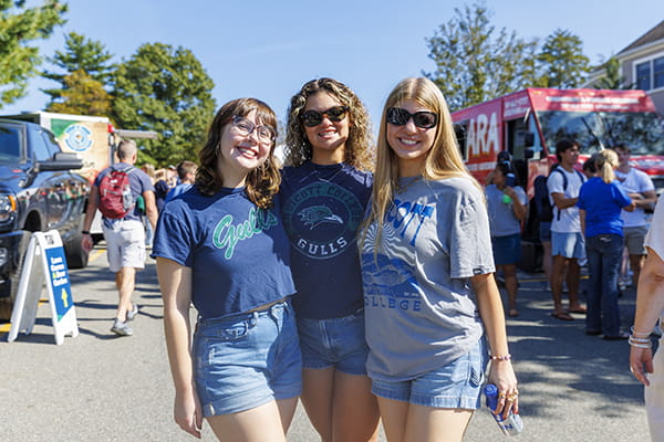 Three students in Endicott gear smile at the camera.