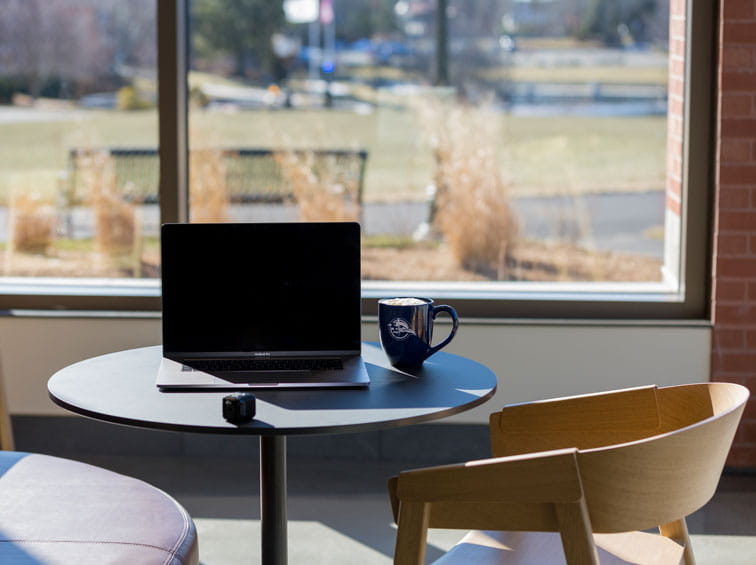 Laptop on table overlooking Endicott campus