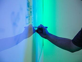 A student writing on a whiteboard
