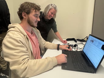 Student at a laptop with a professor