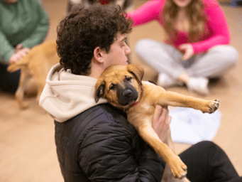 Student holding a puppy