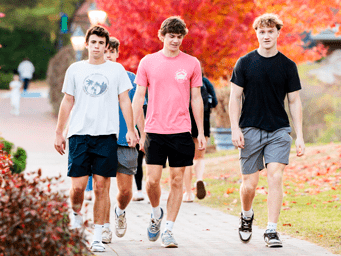 Three students walking through campus