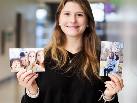 A smiling female student holding up two printed photos.